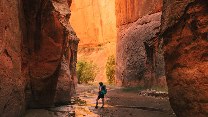 An explorer stands in a slot canyon in Southern Utah
