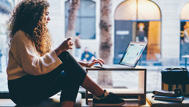 Young woman at shop using laptop