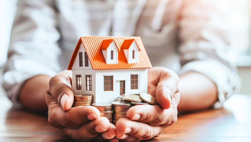 A man holds a miniature replica of a home in his hands