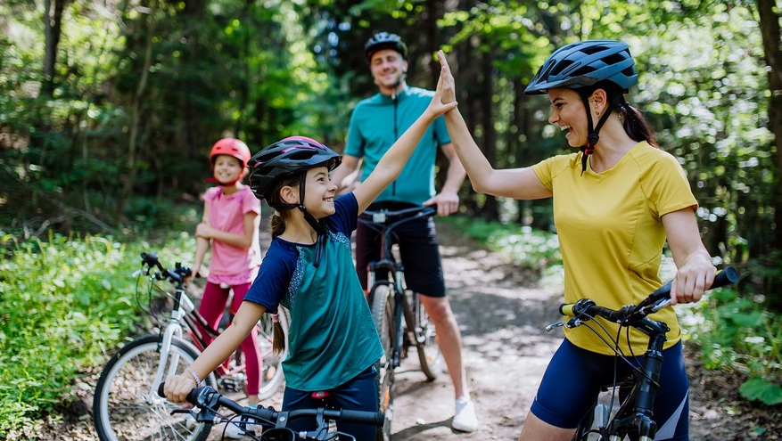 A family of four takes a bike ride on a mountain trail