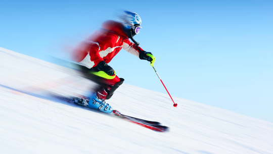A skier speeds down a mountain trail