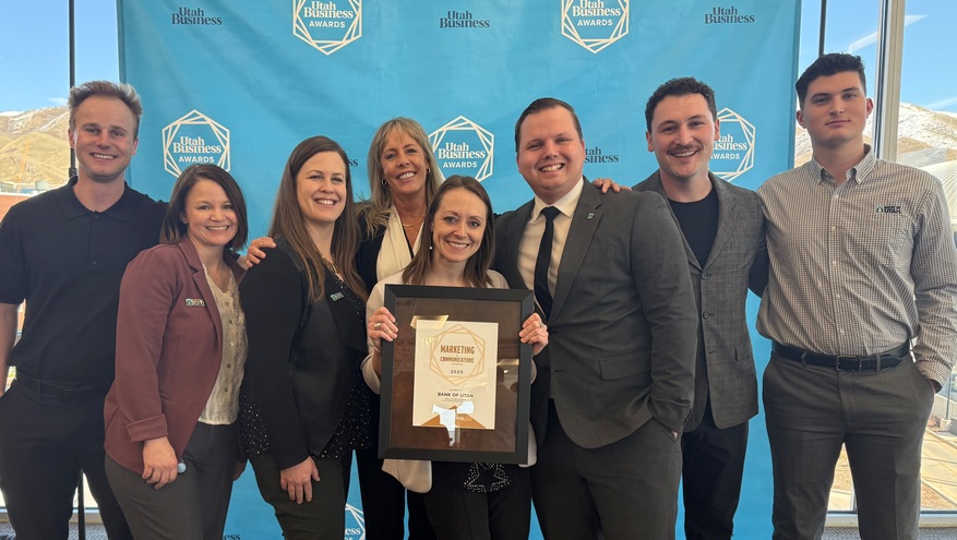Eight Bank of Utah team members smile in front of a Utah Business Awards backdrop, celebrating their 2025 Marketing Communications award.	