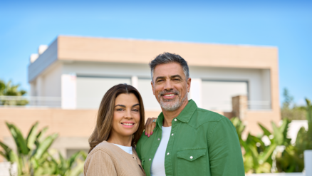 middle aged couple in front of home
