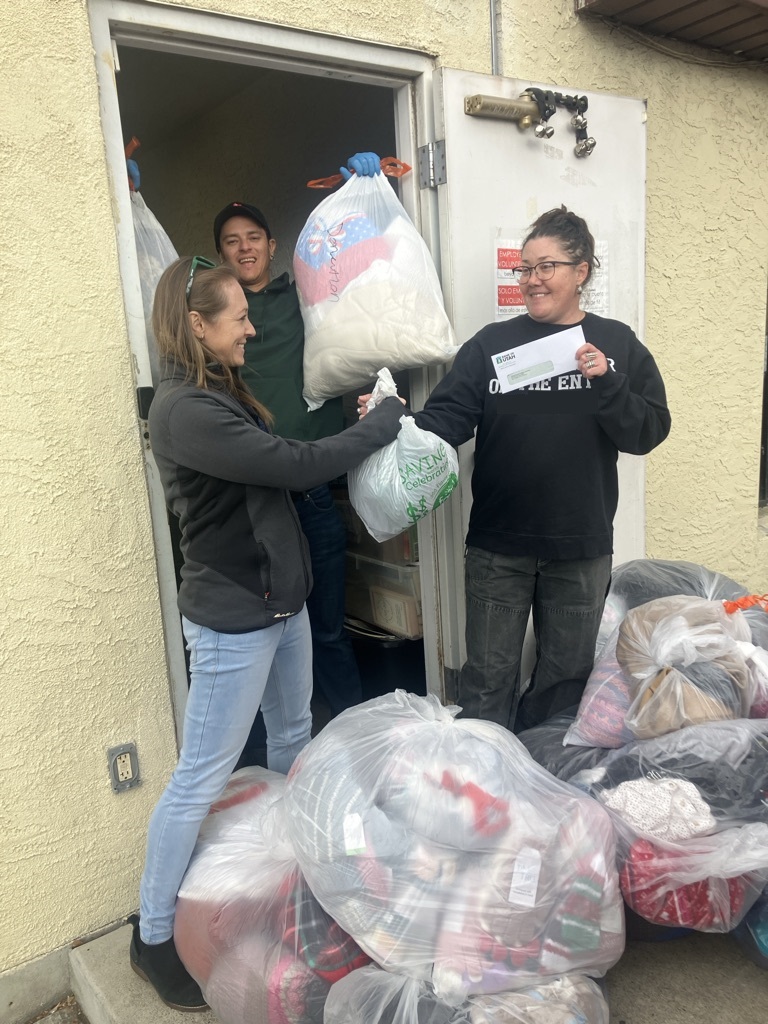 Bank of Utah team members deliver donated clothing and a check to a local partner.