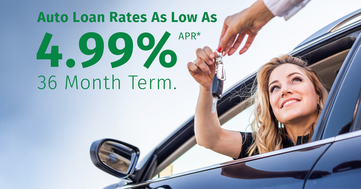 Woman holding car keys and smiling from the driver’s seat