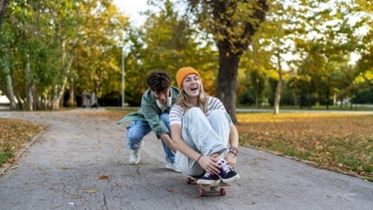 Two skateboarders have fun at a skate park