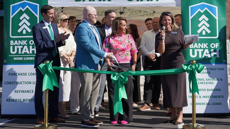 Crowd clapping outside the new Bank of Utah Lehi branch ribbon-cutting ceremony next to a branded tent and banner.
