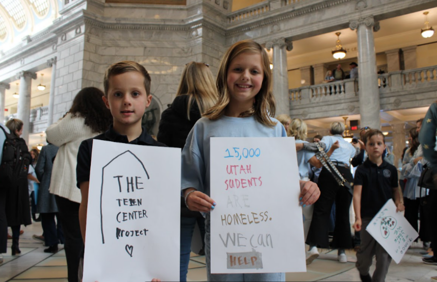 Two children hold handwritten signs supporting Utah Teen Centers at the Utah State Capitol