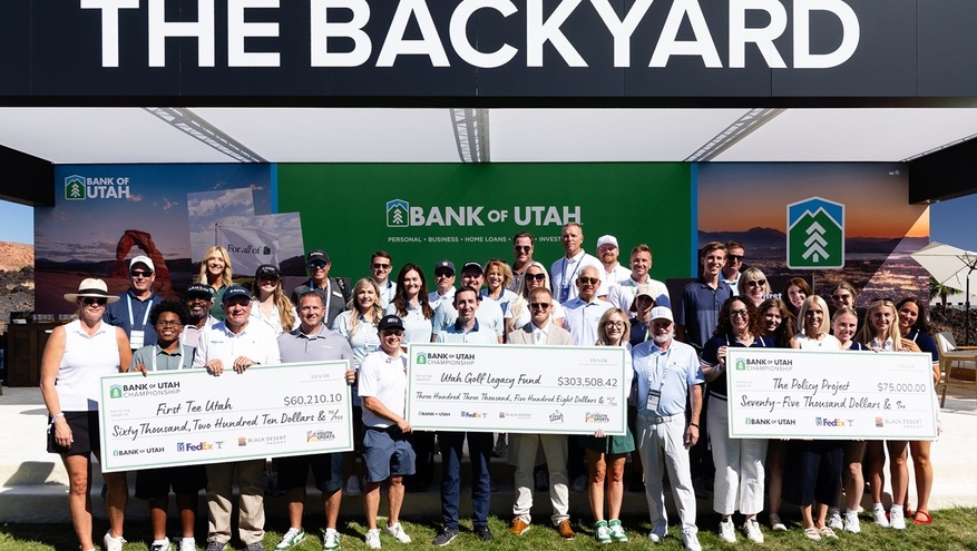 Representatives from Bank of Utah, the Bank of Utah Championship, First Tee – Utah, the Utah Golf Legacy Fund and The Policy Project hold giant ceremonial checks on stage at Black Desert Resort.   