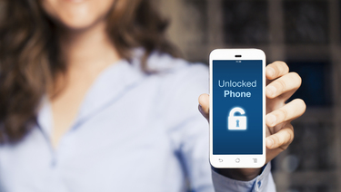 Woman holding smartphone that reads "Unlocked Phone" with unlocked padlock icon on the screen.