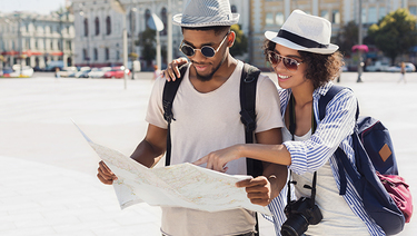 African-american couple looking at map while visiting a European city