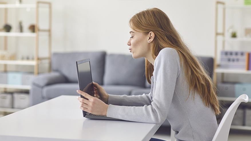 Woman flirting at computer screen while communicating online