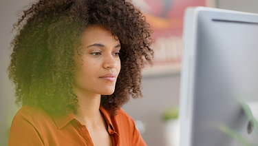 Young woman with a meaningful expression works on a computer