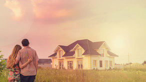 a couple looks at their new home from front yard