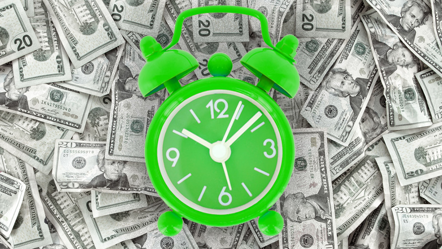 A green analog clock is seen on top of a background of cash money
